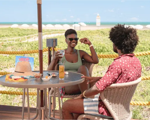 Imagem de duas amigas tomando um drink no bar vila da praia, um dos pontos de consumo do nosso resort all inclusive premium