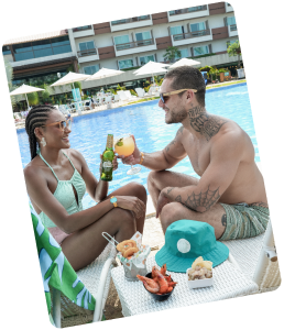 Casal aproveitando bebidas e petiscos na piscina do Mangô Bar no Japaratinga Lounge Resort.