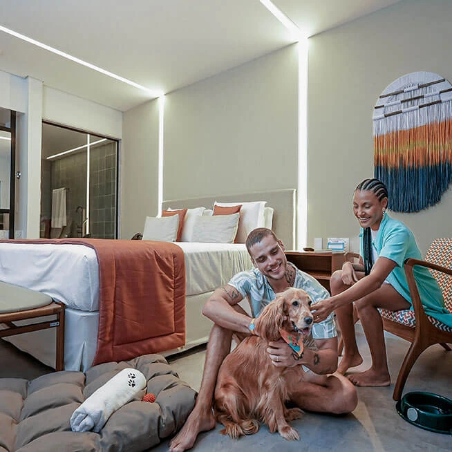 Casal com cachorro no quarto dog-friendly do resort.